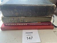 Four vintage religious books stacked showing spines and front edge of the Holy Bible on top