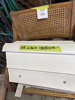 Chair back showing detailed woven wicker pattern and wooden frame, with auction lot label visible.