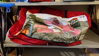 Red carrying bag with tent image and specifications printed on it