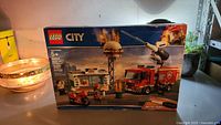 Front of LEGO City set box showing fire truck with water pump and burger joint on fire.