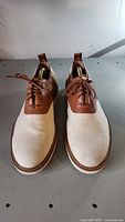 Front view of men's Polo shoes, showing tan leather and beige fabric with laces.