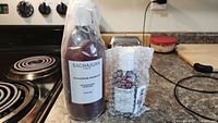 Photo showing Sachajuan Thickening Shampoo 1000 ml bottle with pump dispenser and the smaller conditioner bottle wrapped in bubble wrap next to it on a countertop.