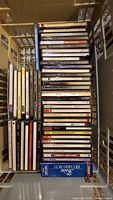 Photo of about 50 music CDs stacked inside a basket, showing various artists and titles including classical and other genres.