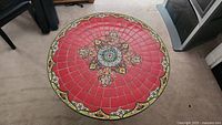 Top-down view of table surface showing full red tile layout and central medallion