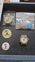Overview of watch parts and dials including Mickey Mouse and Snoopy faces