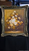 Frontal view of the framed oil painting showing the full bouquet of white and yellow roses in a gold vase with detailed brushwork and ornate gold frame.