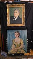 Two framed and unframed original oil portraits, one of a man and one of a woman, shown together hanging and leaning on a black backdrop.