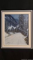 Full frontal view of the framed signed original painting showing a winter mountain road scene with leafless trees.