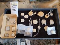 Tray with beige insert and watch components on black background