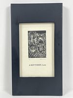 Framed art showing the woodcut print and title under glass with black frame.