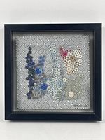 Full view of framed abstract button art showing entire artwork within a black frame.