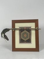 Full view of the wooden framed art piece with feathers, beadwork, and photo-transfer silk panel