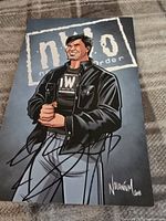 Full front view of the illustrated picture featuring Eric Bischoff in NWO outfit with autograph signature across the bottom.