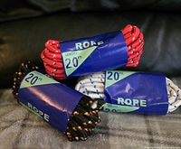 Photo shows three coiled ropes with blue paper labels indicating they are 20 ft. length ropes with 3/8 inch diameter. The ropes are red, white with blue pattern, and black with multicolor speckles.