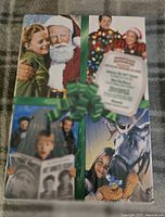Front cover of DVD set showing images from each of the five Christmas movies and green bow graphic wrapping.