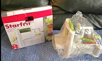 Photo of the spiral slicer still in protective plastic next to the box.