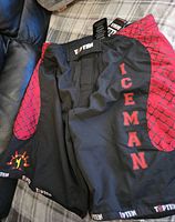 Men's Top Ten kickboxing/MMA shorts in black with red patterned side panels and ICEMAN printed down the leg, new with tags.