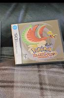 Front of the Nintendo DS Pokémon HeartGold Version game case showing the cover insert with Ho-Oh Pokémon artwork.