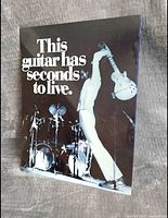 Front view of the metal sign showing Pete Townshend smashing a guitar with text 'This guitar has seconds to live'. Black and white image.