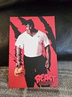 Close-up front view of signed Ahmed Johnson postcard showing signature and details