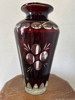 Front view of antique ruby flashed art glass vase showing clear cut-to-clear floral and oval designs.