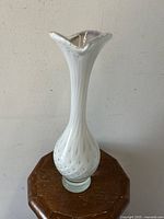 Full view of the white controlled bubble Scandinavian art glass vase on wooden table.