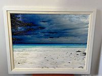 Full view of framed painting showing beach and sky composition