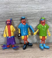 Three bendable Nathan's Hot Dogs The Franksters toy figures with baseball theme, shown side by side on wooden surface.