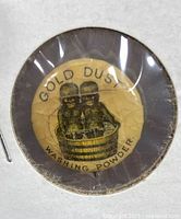 Close-up front image of the round celluloid pinback button featuring Gold Dust Washing Powder advertisement with two children in a washtub.
