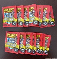 15 unopened Topps Desert Storm Homecoming Edition 3rd Series trading card wax packs laid out flat on a dark surface showing the front of packs.