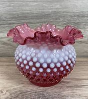 Front view of 5 inch Fenton hobnail vase with cranberry opalescent glass and ruffled rose rim, showing texture and color gradient.