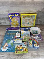 Top view of Care Bears items spread on table including books, puzzle, bowl, toys and art
