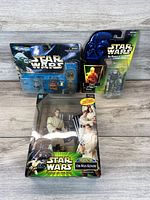 Photo showing three sealed Star Wars action figure sets: Micro Machines featuring Anakin Skywalker and Sebulba, Darth Vader from Power of the Jedi, and Obi-Wan Kenobi with supplementary figures.