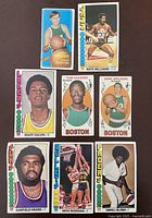 Seven vintage basketball cards featuring various players with team names including Boston, Lakers, Suns, Bullets and Clippers.