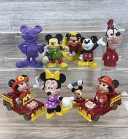 Photo showing all 10 vintage Disney 1990s Applause PVC figures including Mickey Mouse, Minnie Mouse, Goofy, and chipmunk characters with fire trucks.