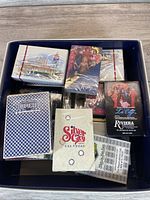 Top view of multiple decks of vintage Las Vegas themed playing cards in a box, showing variety of designs and casinos represented