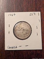 Obverse side of 1967 Canadian 25 cent coin showing a lynx design with denomination and year.