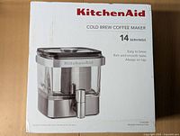 Front of the box showing KitchenAid Cold Brew Coffee Maker in stainless steel with tap, 14 servings.