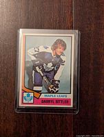 Front side of 1974-75 Darryl Sittler Toronto Maple Leafs hockey card inside plastic protective sleeve, showing photo of player and team name.