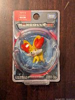 Front view of Pokemon Fennekin figure in original blister card packaging showing figure and branding.