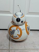 Front view of the BB8 toy, showing the spherical body, colorful panels, and antenna on the dome-shaped head.
