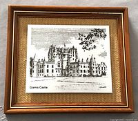 Framed detailed etching artwork of Glamis Castle mounted on yellow burlap background within a wood frame with gold trim.
