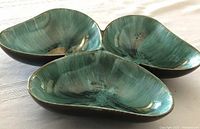 Top view showing green swirl glazed interior of the three leaf clover sections of the serving dish with curved edges.