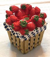 Front angle of the strawberries basket with detailed strawberry lid and checkered cloth lining.