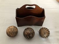 Wood stationary desk box alongside three decorative carved wood balls showing front and carved patterns.