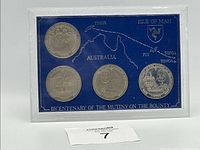 Front view of the 4 coin set displayed on blue background with map and Isle of Man crest