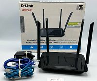 Front view of D-Link Amplifi Wireless AC1200 router with box, power adapter, and Ethernet cables.