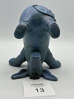 Back view of the blue Eeyore figurine standing upside down showing tail and mane details.