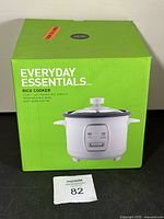 Front view of green box featuring image and brand name Everyday Essentials rice cooker 6 cup capacity.