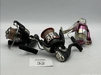 Three fishing reels placed side by side, showing overall appearance and fishing lines attached.